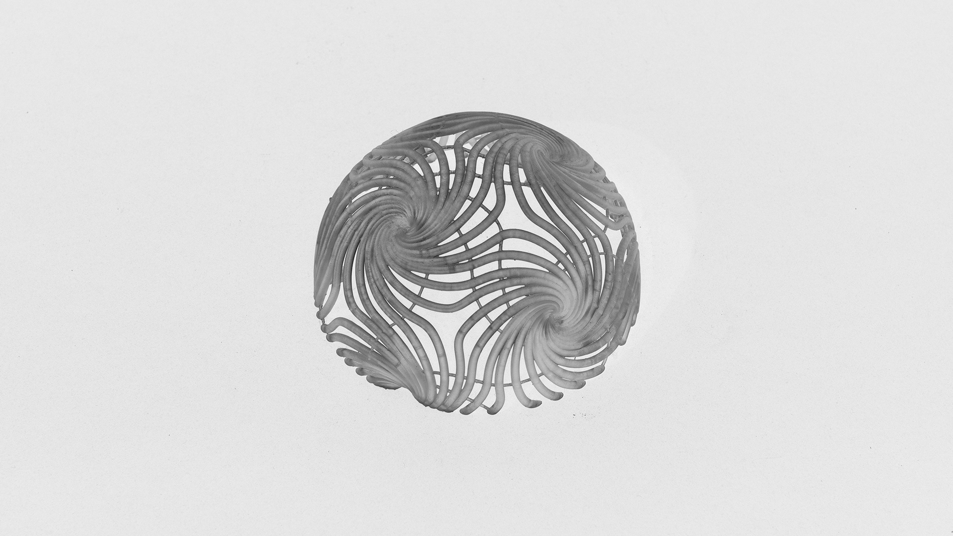 A spherical 3D printed resin sculpture with intricate spiral patterns.