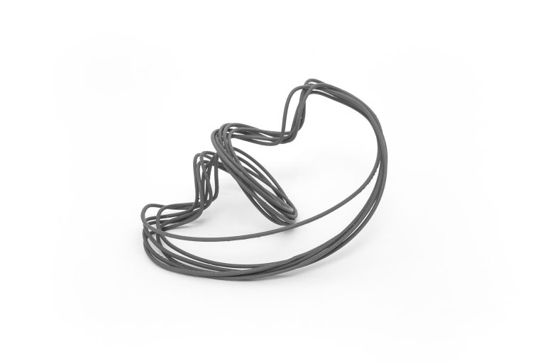 Black wire sculpture with spiral pattern, shaped as a large ring.