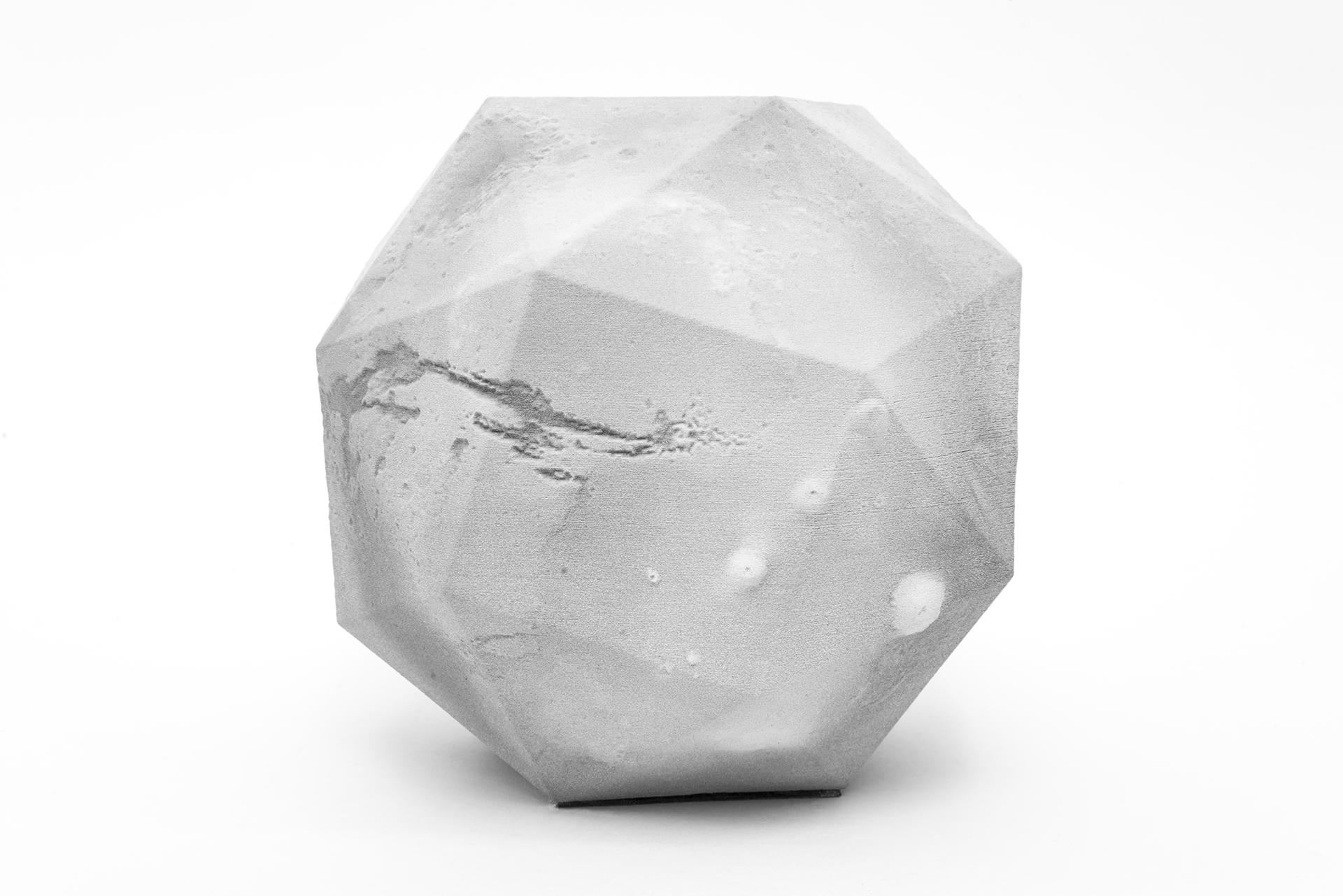 Grey stone with rough texture on white surface.