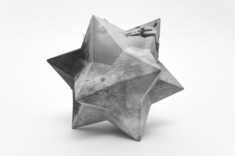 A small 3D printed resin sculpture designed with a star-like shape and intricate details.