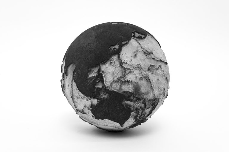 A smooth and rough textured spherical sculpture.