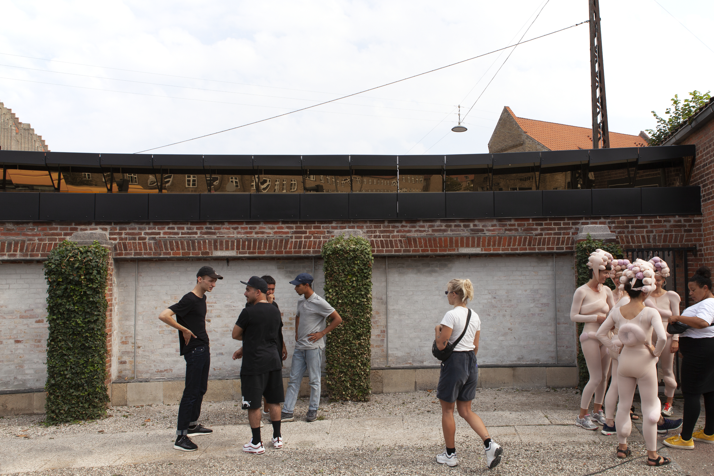 Group of people interacting with sculptures made from coated stainless steel.