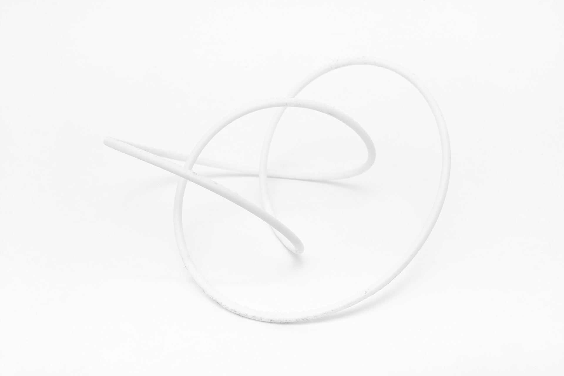 This image shows a sculpture composed of white 3D printed resin, presenting the form of a knot.