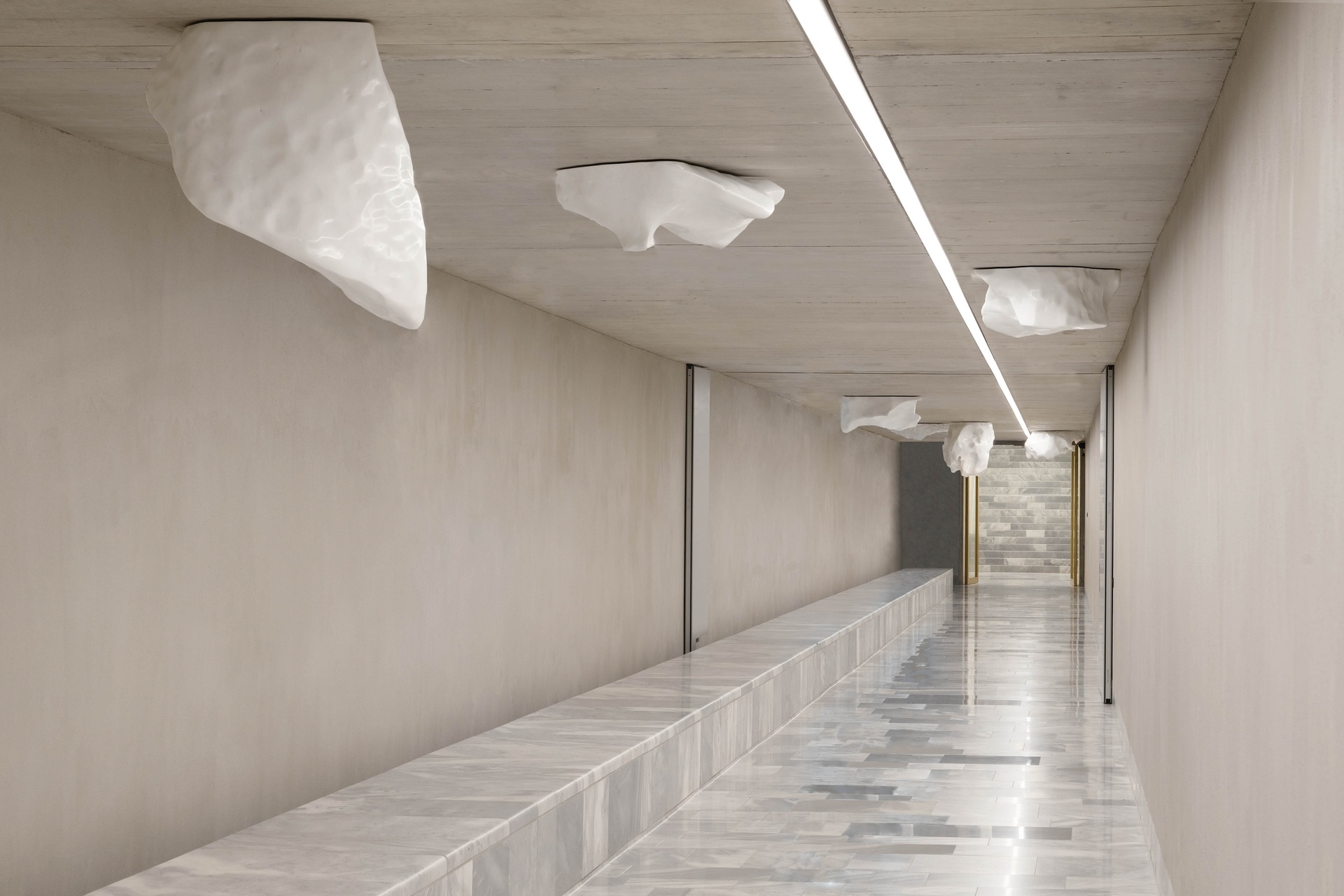 The image shows a Carrara marble sculpture in an underground tunnel, replicating ice chunks from Diamond Beach, Iceland.