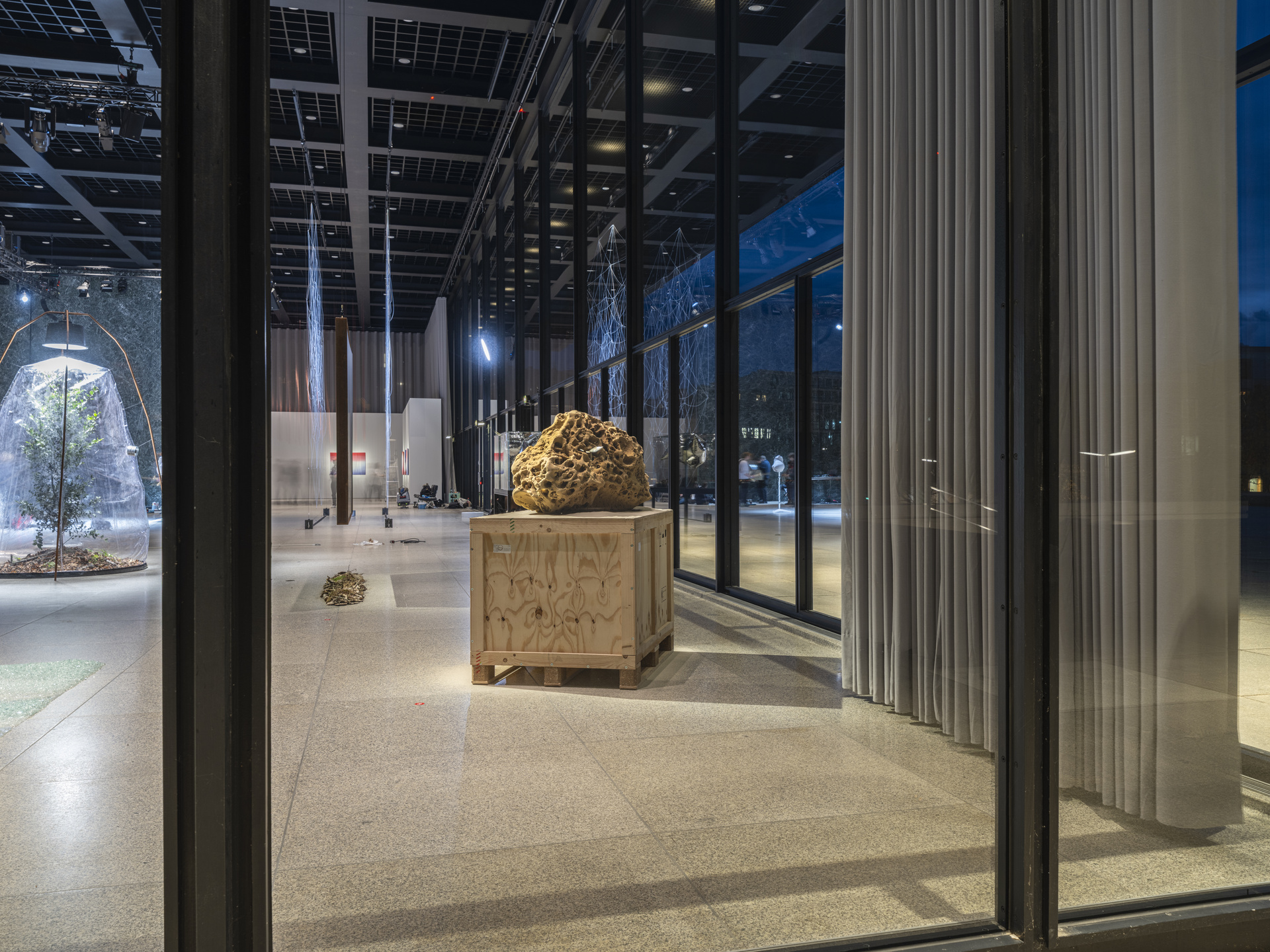 Modern art piece featuring sand sculpture in a gallery setting at night.