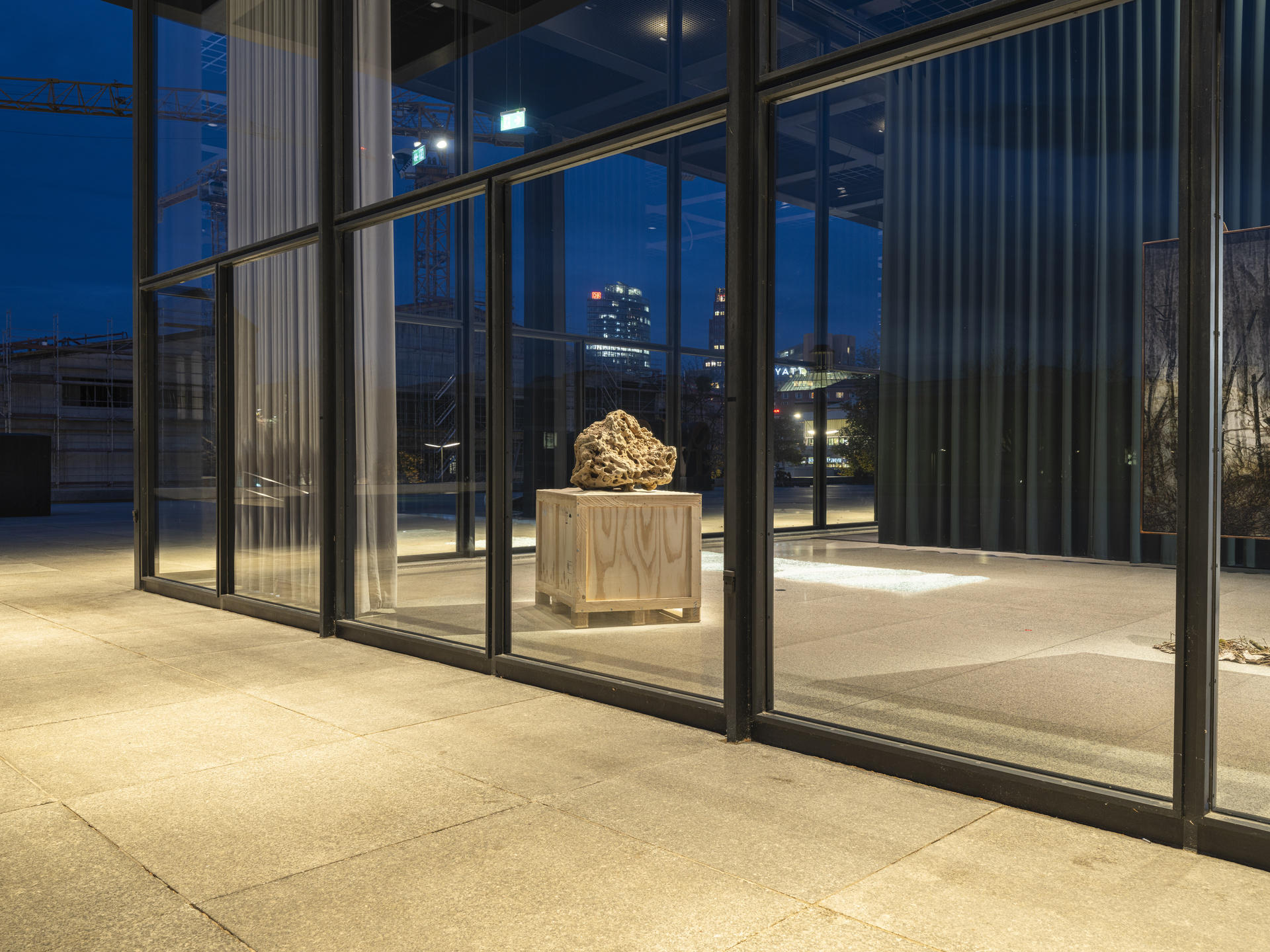 Modern sculpture with sand texture displayed in black frame structure.