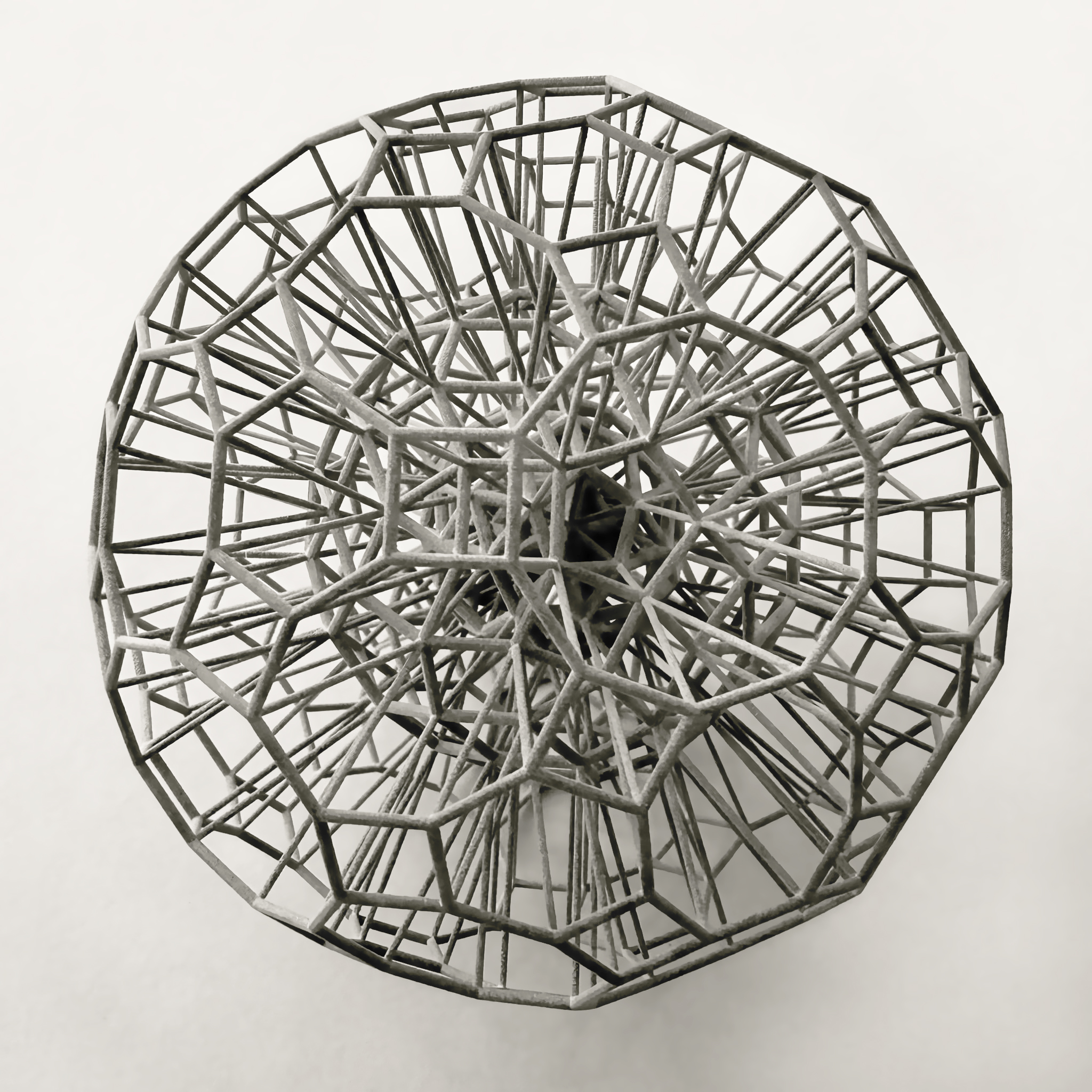 Grey spherical sculpture with intricate wire frame pattern.