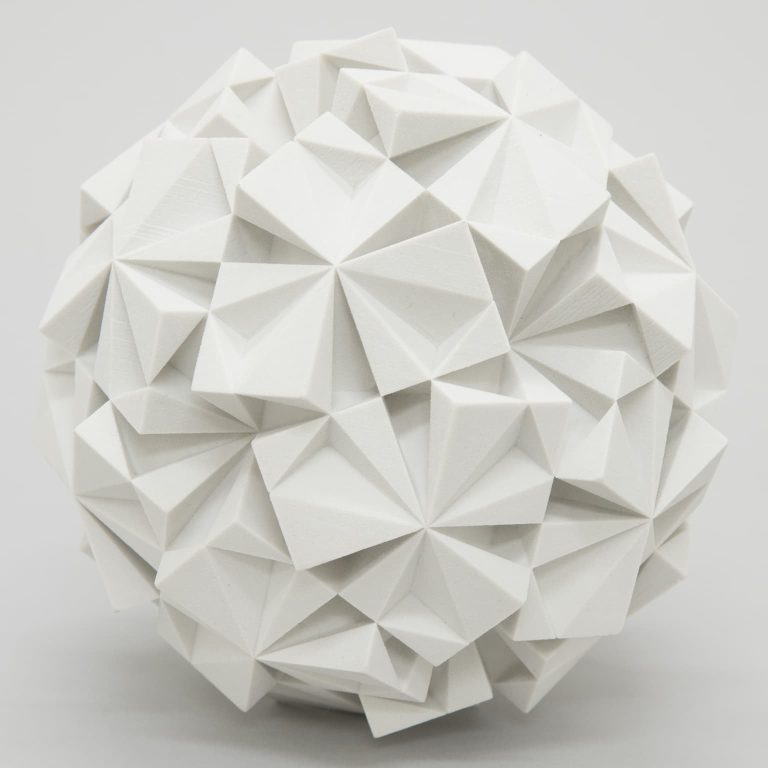 White plaster sculpture of an icosahedral dodecahedron with intricate geometric patterns.