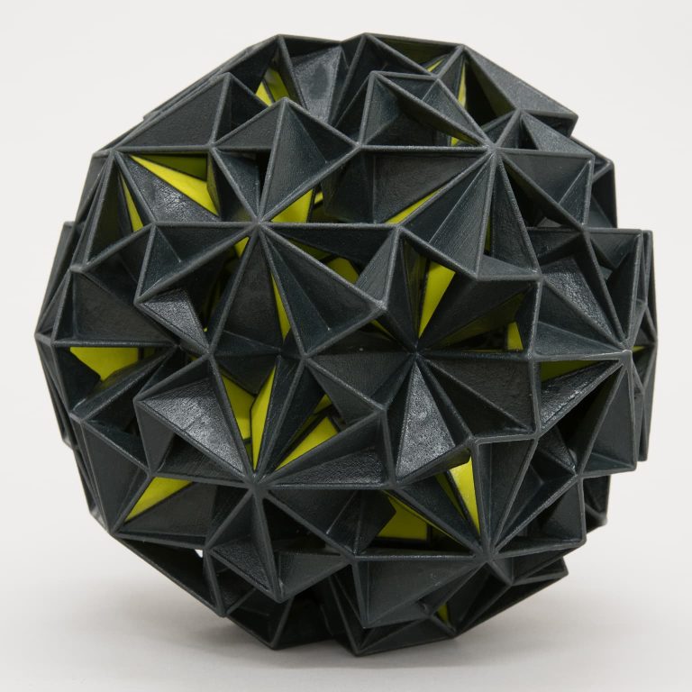 A black and yellow sphere sculpture with a rough texture.
