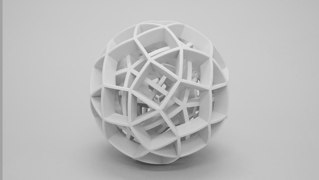 White 3D-printed spherical structure sits on a plain surface.