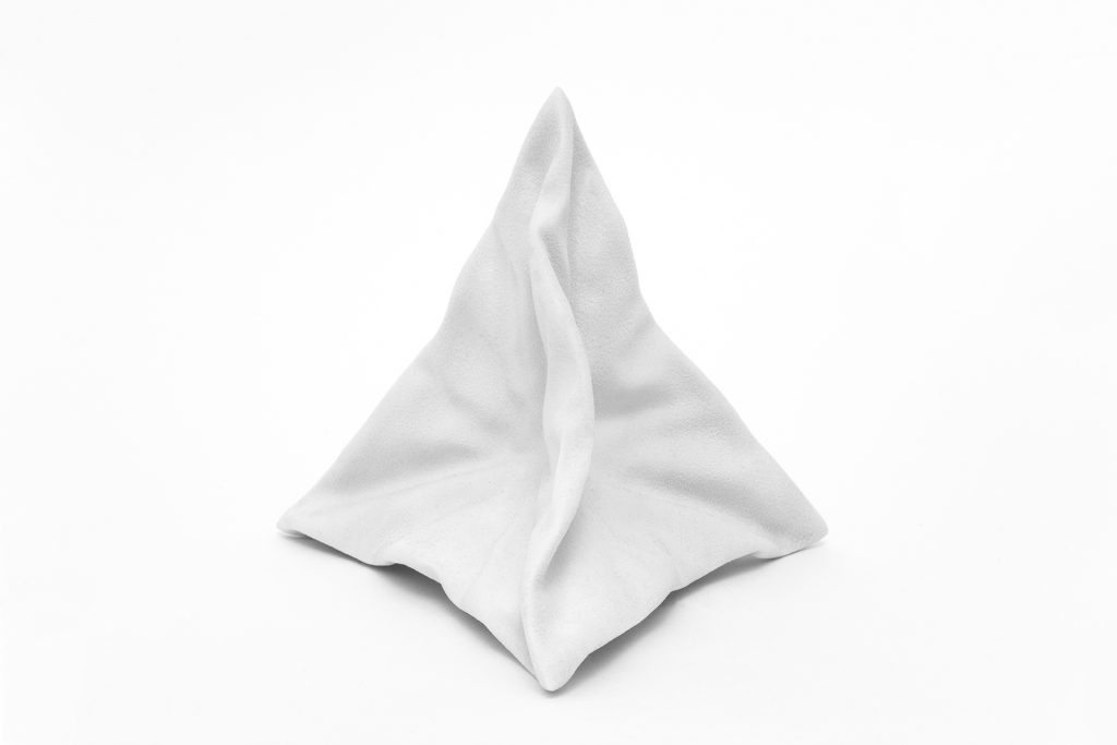 White 3D-printed resin object sits on white background.