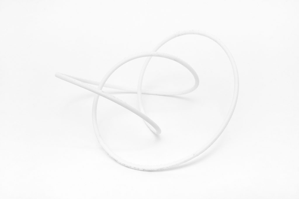 White 3D-printed resin knot model sits on white surface.