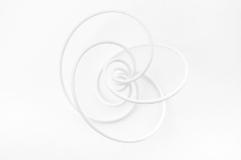 3D printed resin knot model sits on white surface.