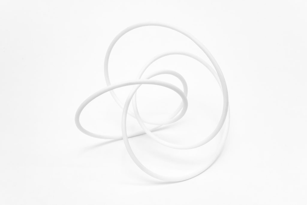 White 3D-printed resin knot model sits on white background.