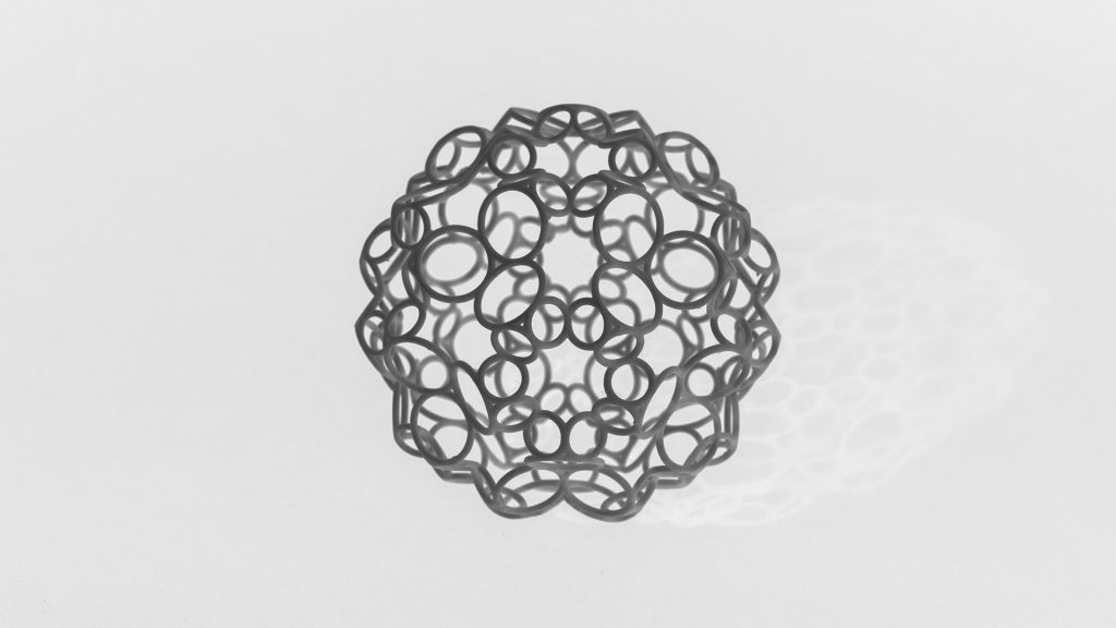 Sphere made of 3D printed resin sits on white surface.