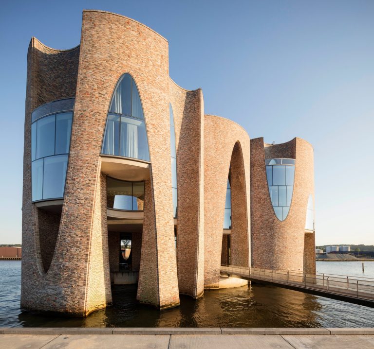 Fjordenhus is a brick building with four intersecting cylinders, 28m high, located by water.