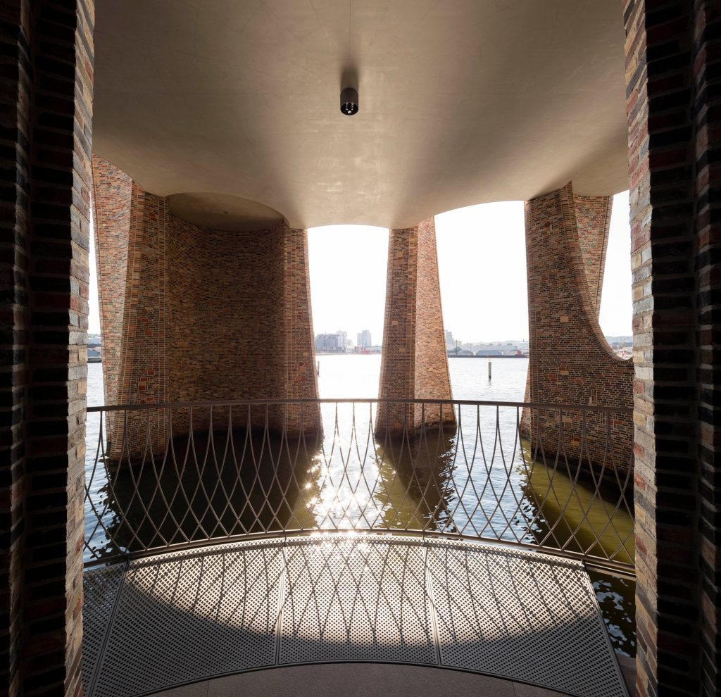 Fjordenhus, a brick building with four intersecting cylinders, sits by the water.