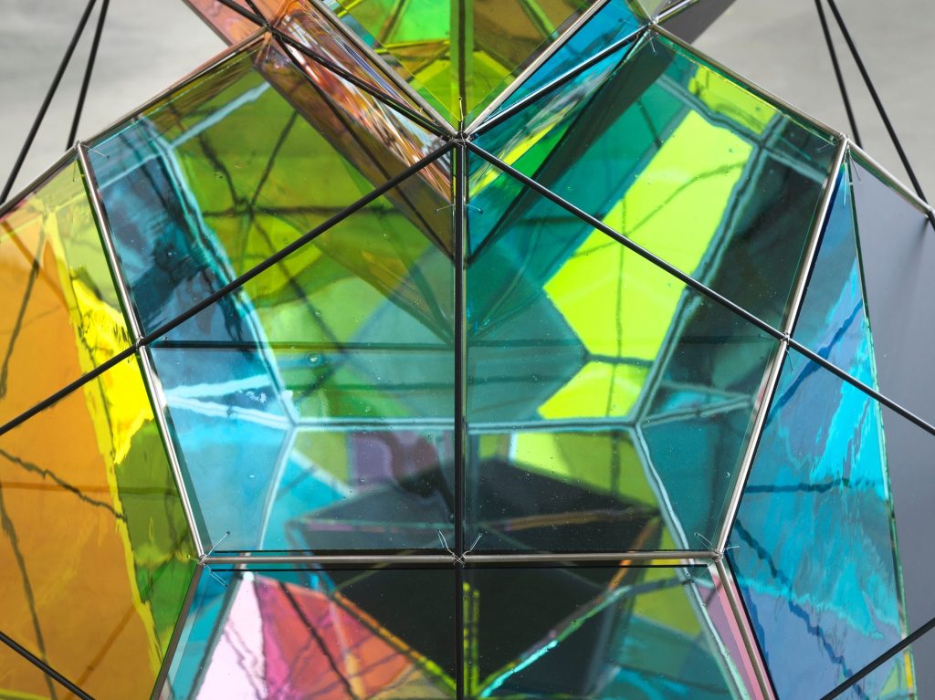 Colorful glass geometric structure in 'Probability of conscious gravitation' installation.