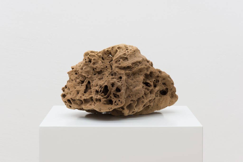 3D printed sand sculpture sits on white pedestal.