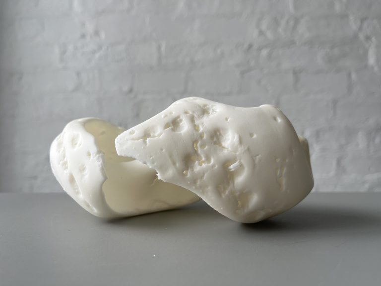 White 3D printed resin object sits on gray surface.