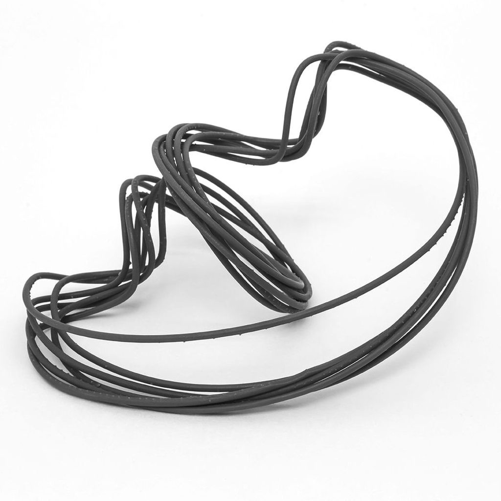 A black 3D printed resin tube forms a spiral double vortex on a white surface.