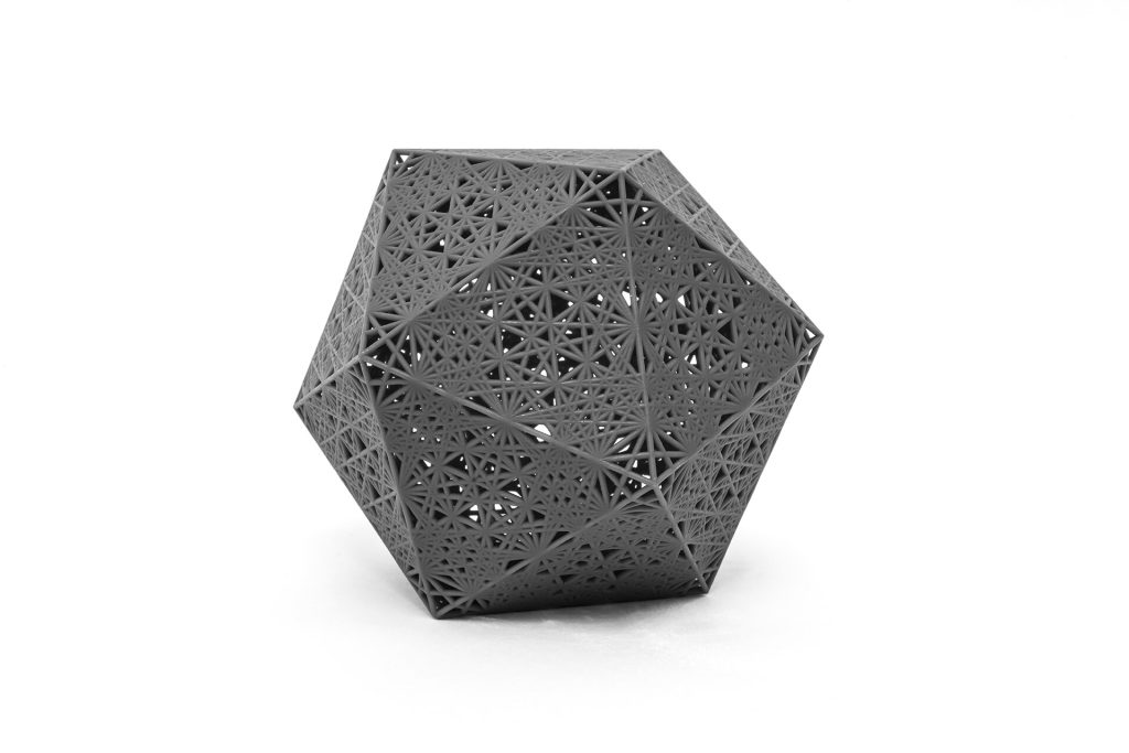 A gray, 3D-printed resin object displays quasicrystalline tiling patterns on its polyhedral surface.