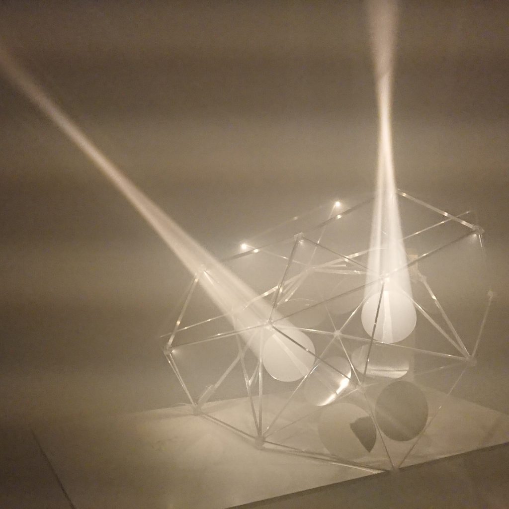 A 3D printed resin polyhedron holds parabolic mirrors that project light cones.