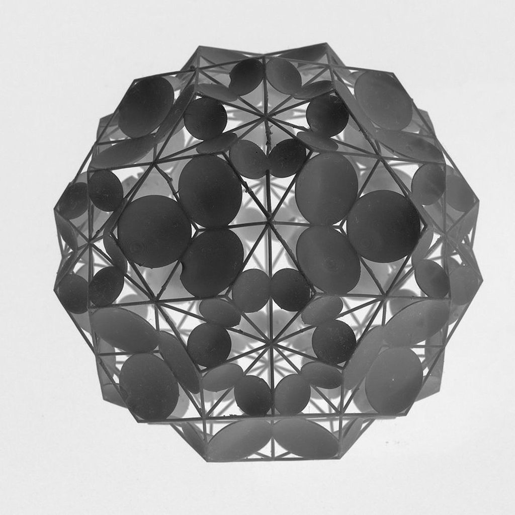 A 3D printed resin polyhedron holds parabolic mirrors on its faces.