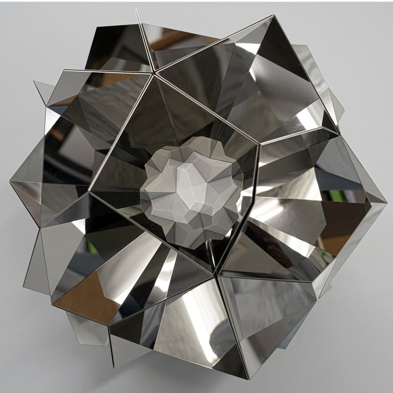A stainless steel and 3D printed resin sculpture forms a mirrored, polyhedral shape with a central resin core.