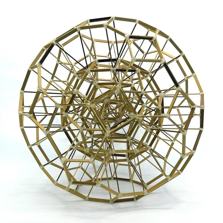 A layered polyhedral framework made of 3D-printed nodes and wooden beams forms a spherical structure with interconnected geometric shapes.