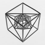 3D printed resin nested polyhedra sit centered on a white surface.