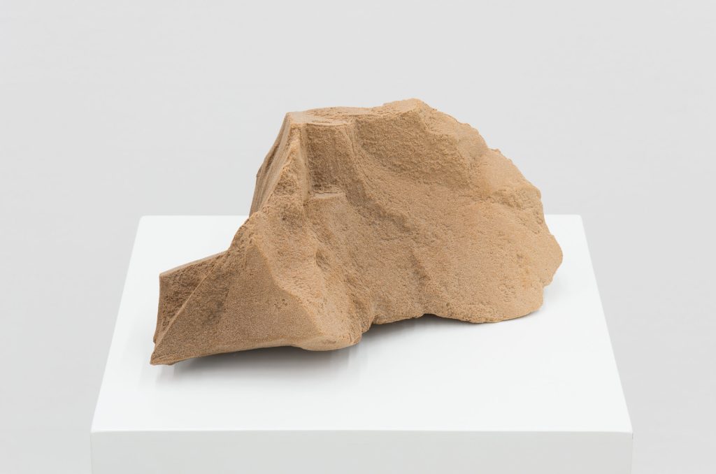 A 3D printed sand sculpture sits on a white pedestal.