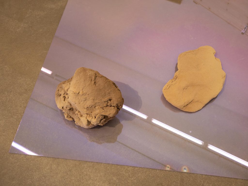 Two 3D-printed sand sculptures sit on a transparent sheet.