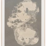 A framed screen print displays sand particles from Senegal embedded in ink on paper, forming an abstract shape against a textured gray background.