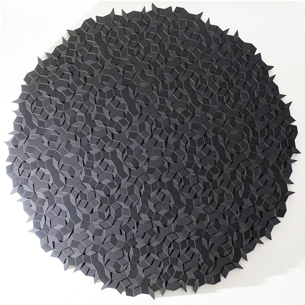A circular resin 3D-printed sculpture composed of black geometric tiles arranged in an aperiodic pattern.