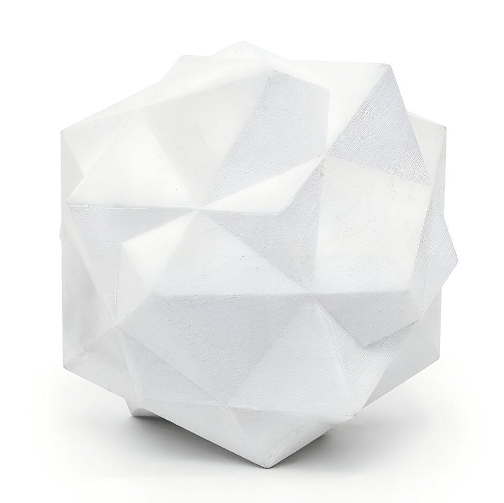 A white 3d printed resin geometric compound sits on a white surface.