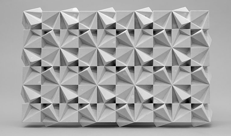 A 3D printed resin wall uses four-cube blocks with voids to form a grid of alternating rotations.