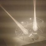 Light beams reflect off parabolic mirrors inside a 3D printed resin polyhedron.