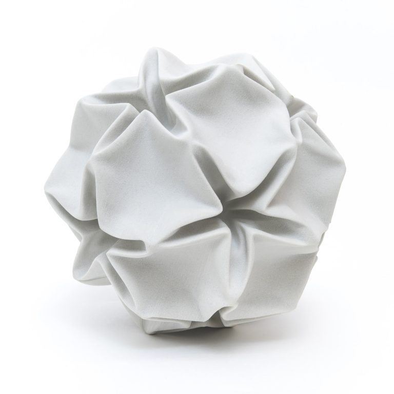 A 3D-printed plaster model of a deformed rhombic triacontahedron stellation sits on a white background.