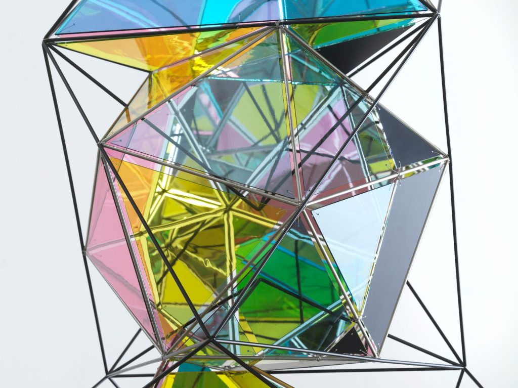 Painted polyhedral elements connect at metal joints against a white background.