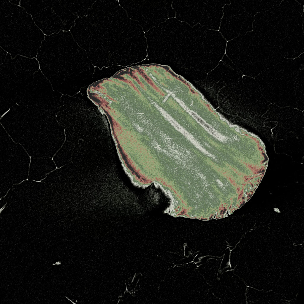 A green and red sand grain cross-section sits on a black background with white crack lines.